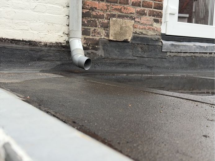 Hemelwaterafvoer die op een plat dak loost